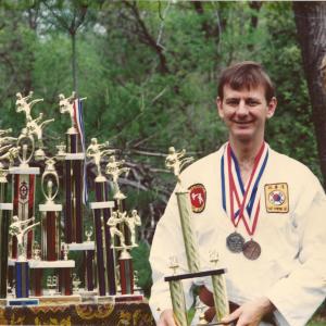 Gus Rhodes with the ten trophies which he won during the two years that he competed in Martial Arts Tournments In the 1988 State Athletic Games he won the bronze medal for sparring and won the silver medal at the State Games the following year He won the