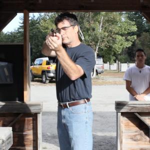 An expert marksman Henri Miller practices at a shooting range while his son Gary watches