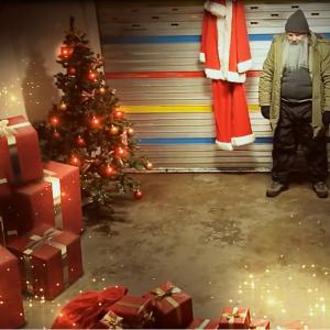 Still of Dean Dawson as the Real Santa in his garage with Rudolf for a Gift Topping commercial