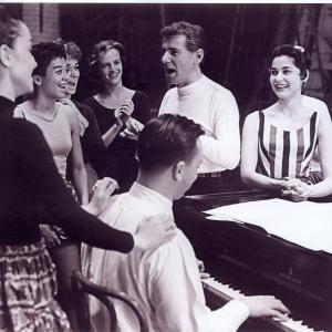First day of rehearsal of West Side Story To Carols right is Leonard Bernstein At the piano is Stephen Sondheim Chita Rivera gives him a back rub