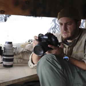 Robert L. Cunningham takes a moment to review footage during takes in Eastern Afghanistan, 2011.