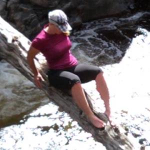 Wild Woman Kellie Nightlinger crosses a raging river on a narrow log