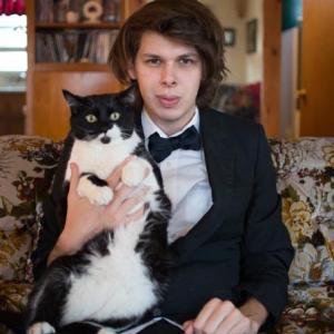 Matty Cardarople in a Tuxedo with his tuxedo cat Hunter.