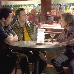 Elliot THE ROCK Raji VINCE VAUGHN and Nick Carr HARVEY KEITEL discuss business in MGM Pictures comedy BE COOL
