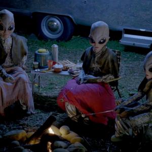 GEICOs AMAZING COMMERCIAL SERIES Amazing Aliens From left to right actresses Karyn Malchus Brianna Gardner and Kyra Elise Gardner in full prosthetic makeup as the Amazing Alien family camping out by the fire and roasting marshmallows