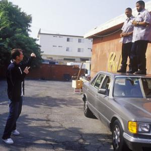 left to right Director Marcus Raboy instructs stars Mike Epps and Ice Cube how he wants them t o jump off the car