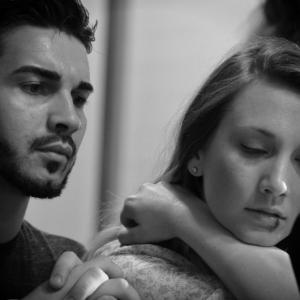 Actors Phil Araujo and Caitlyn Fletcher between takes on the set of The Red Suit