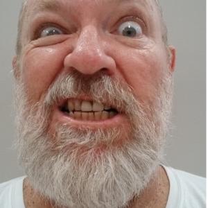 Older white bearded man with bald head, snarling at camera. Dec 2014