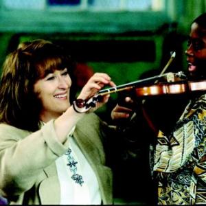 Roberta instructs a boy in playing the violin