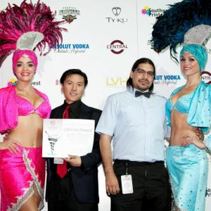 Cal Nguyen and Tim Sabuco with showgirls at the 2012 Las Vegas Film Festival, holding the Official Finalist award in the TV Pilots Competition for Day Zero the Series' pilot episode, 