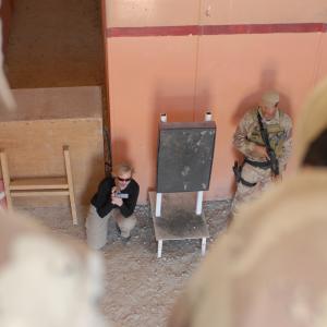 War Reporter Alex Quade shooting video in Iraqi shoothouse used for live fire training Iraq 2008