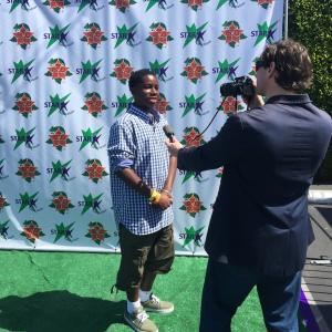 Prophet being interviewed on the green carpet at the 15th Annual Star Eco Stations Childrens Earth Day event