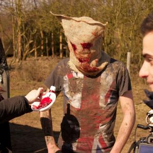 Makeup artist Justine Carter applies finishing touches to actor Liam Ponder with Mark Castro on set of sci fi horror short Blues Skies