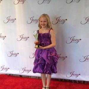 All Smiles on the Red carpet with her Joey Award. Smiling for the Press.