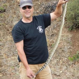 Capt Bill with a formerly grumpy rattlesnake now dispatched