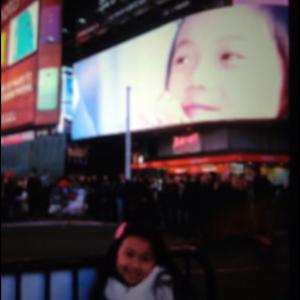 Raina Cheng in front of her Bank of America Commercial on a Times Square Jumbotron TV. 2013