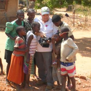 While working on a documentary Dan takes time to show Ugandan kids how his camera works.