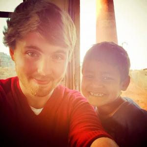 Tom Cullingham with child at a Kathmandu brick factory.