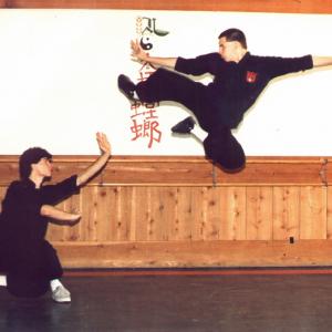 Michael Dawson in midexecution of a flying kick as kungfu brother Guy Horton maintains a defensive position 1986