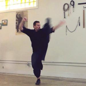 An outside crescent kick by Michael Dawson, during the performance of a Northern Shaolin kung-fu form (2014).