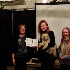 Fiona Hodgson accepting the 1st place youth produced category award for Meow The Itinerary Accompanied by the films DP Cat Schultz and Fionas dog Bandit
