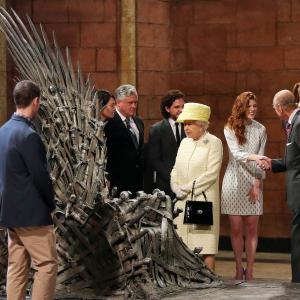 Queen Elizabeth II meets cast members of the HBO TV series 'Game of Thrones' Lena Headey and Conleth Hill while Prince Philip, Duke of Edinburgh shakes hands with Rose Leslie as they views some of the props including the Iron Throne on set in Belfast's Titanic Quarter on June 24, 2014 in Belfast, Northern Ireland.