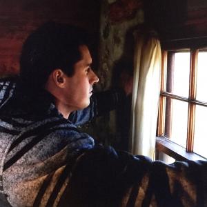Behind the scenes photo of Keegan taking a moment to peer out the window and look at the stunning landscape