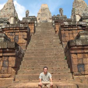 This is a picture of me sitting on a temple in Cambodia.