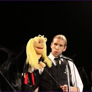 Still of Corey Tomicic and puppet Millie performing at the Candyass Cabaret