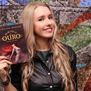 Carolina Munhz with her book Por um toque de Ouro